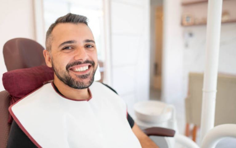 Smiling man in a dental chair, ready for periodontal surgery or dental implants in Atlanta.