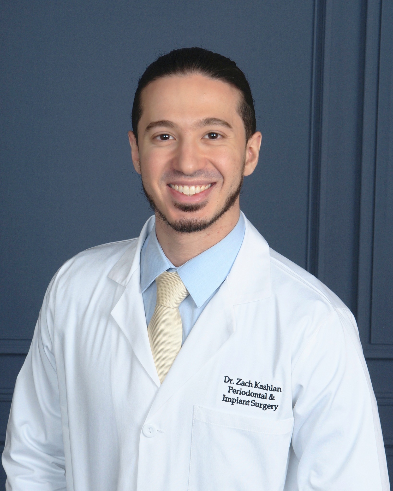 Periodontist Dr. Zach Kashlan in white coat, specializing in periodontal surgery and dental implants in Atlanta.